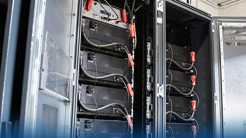 Ein von Wirsol installierter Batteriespeicher mit mehreren Energiezellen in einem Metallschrank. Das System dient zur effizienten Energiespeicherung und hilft Unternehmen, ihre Stromkosten zu senken.